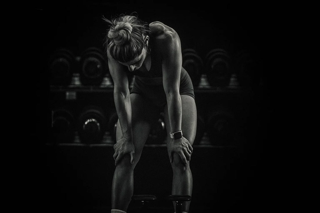 Exhausted athlete recovering on gym floor after intense training session.