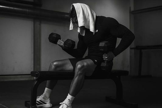 Focused athlete lifting weights in a minimalist gym environment.